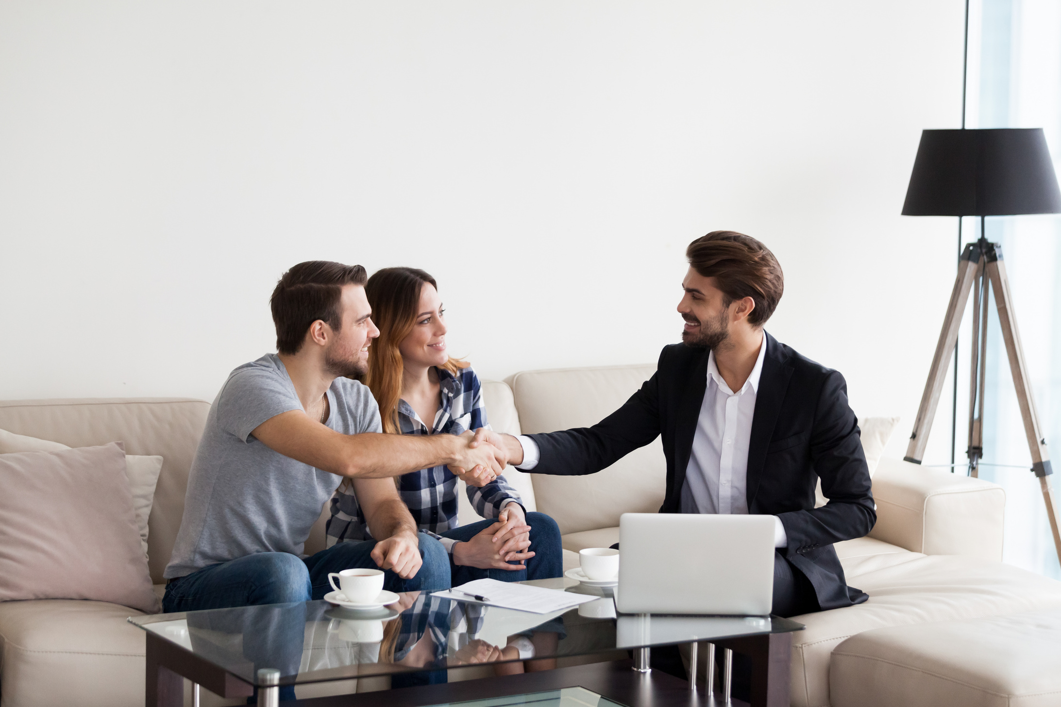 Young couple, family making deal with Real Estate Agent, interior designer